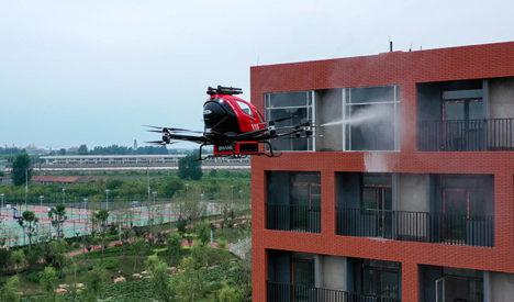 Electric vertical and takeoff vehicle shooting water on a fire in a high rise.