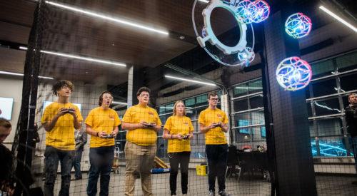 a team tries to score points by remote controlling their drones toward a target goal.