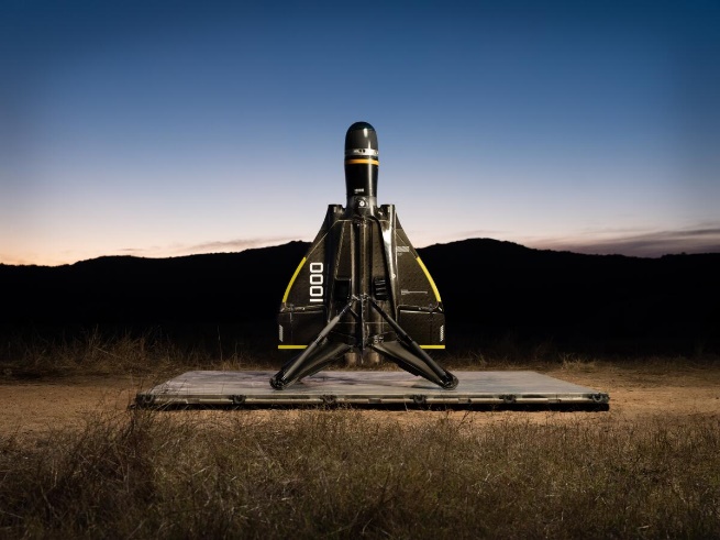 Roadrunner attack drone sitting in foreground against a dusky landscape.