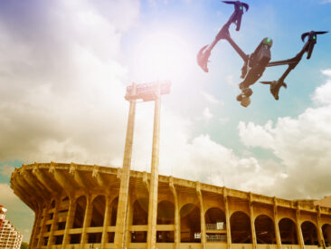 A drone flying outside a sports stadium about to enter the venue